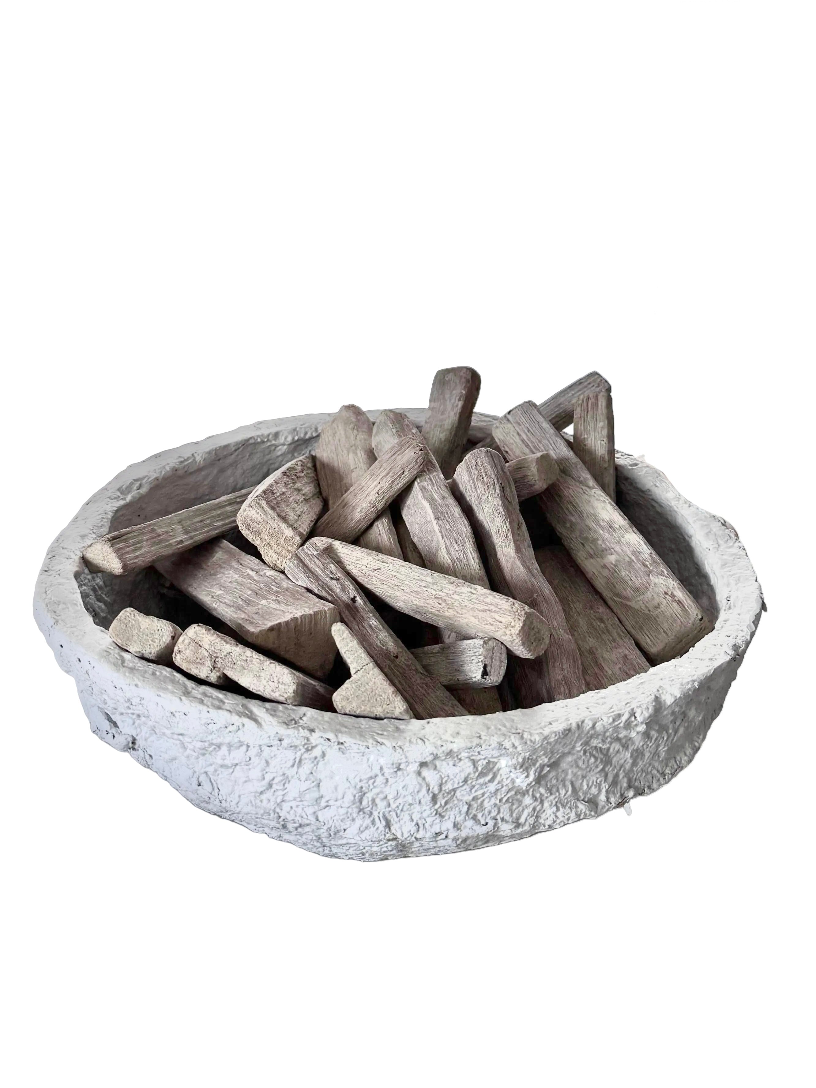 White plaster bowl full of driftwood pieces styling rental